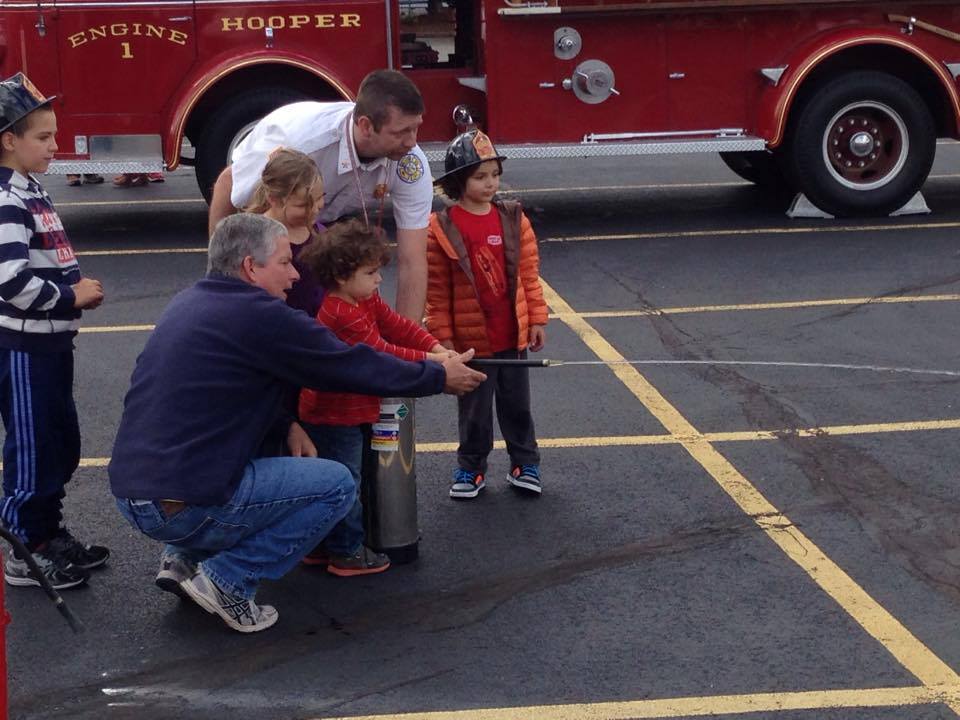 Apalachin firefighters teaching children how to use a fire extinguisher during a community education program